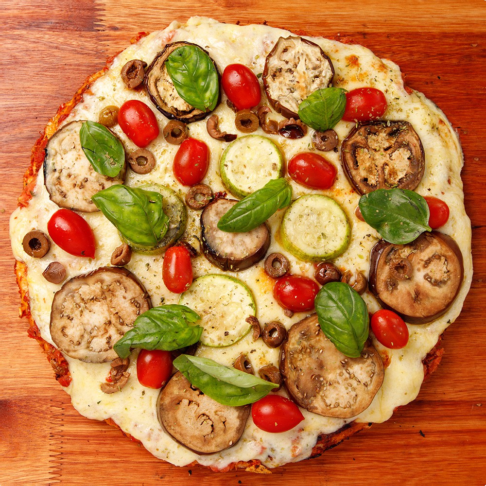 Vegetariana - Salsa de tomate, muzzarella, zucchini asado, berenjena asada, tomates cherry confitados, aceitunas negras y hojas de albahaca.<br />
